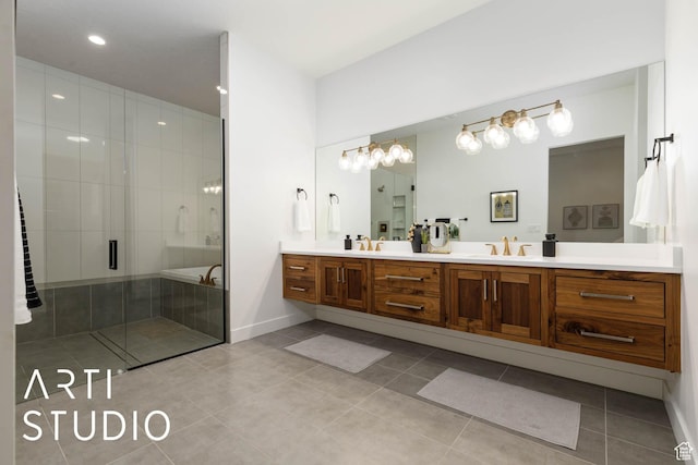 full bathroom featuring double vanity, a stall shower, baseboards, tile patterned flooring, and a sink