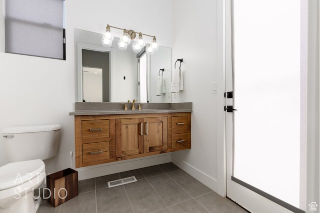 bathroom featuring visible vents, baseboards, toilet, tile patterned flooring, and vanity