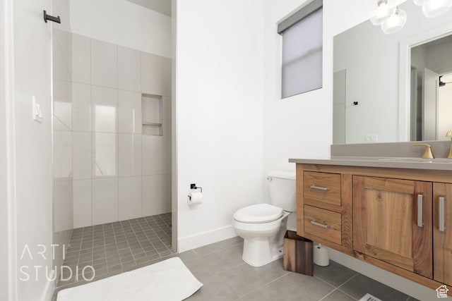 full bathroom featuring toilet, vanity, baseboards, tile patterned floors, and walk in shower