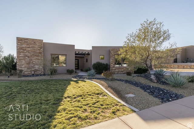 adobe home with a front yard and stucco siding