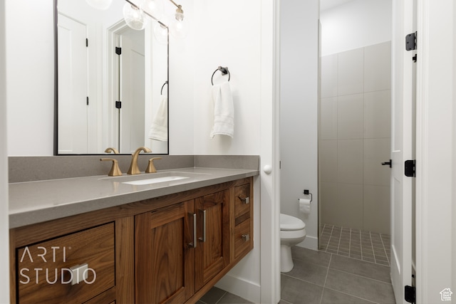full bath featuring toilet, vanity, tiled shower, and tile patterned floors