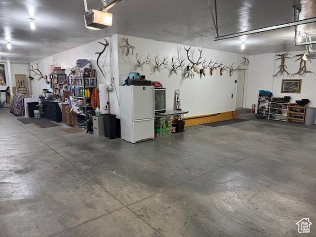 355 S 200 W, Orangeville, UT 84537 - garage featuring white refrigerator and a garage door opener
