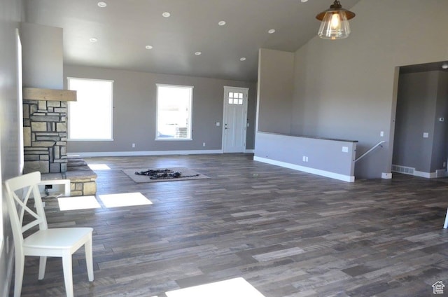 355 S 200 W, Orangeville, UT 84537 - unfurnished living room featuring a fireplace, a towering ceiling, and dark wood-type flooring