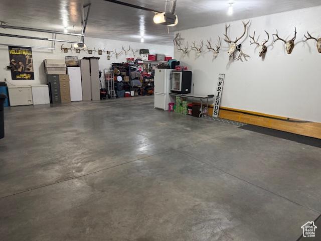 355 S 200 W, Orangeville, UT 84537 - garage with white fridge and a garage door opener