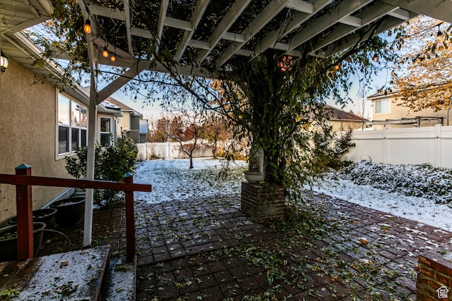 snowy yard featuring a patio area