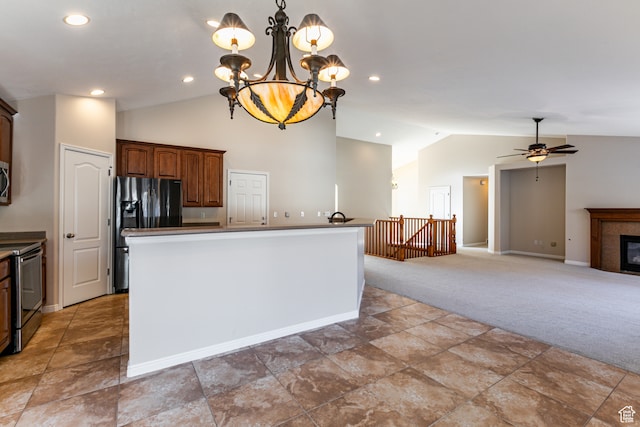 kitchen with carpet flooring, ceiling fan with notable chandelier, stainless steel appliances, vaulted ceiling, and hanging light fixtures