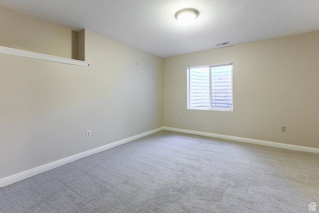 empty room featuring a textured ceiling and carpet floors