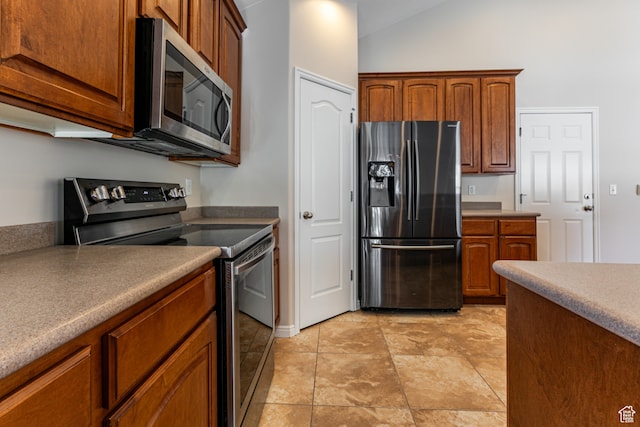 kitchen with appliances with stainless steel finishes and vaulted ceiling