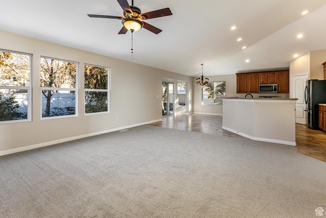 616 W 3200 N, Lehi, UT 84043 - unfurnished living room featuring light colored carpet, baseboards, lofted ceiling, a ceiling fan, and a chandelier