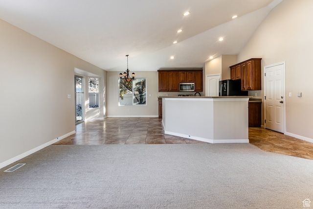 kitchen with an inviting chandelier, black fridge, an island with sink, pendant lighting, and light carpet