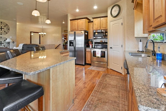 545 N 1100 E, Beaver, UT 84713 - kitchen featuring appliances with stainless steel finishes, a sink, a breakfast bar, decorative backsplash, and a chandelier