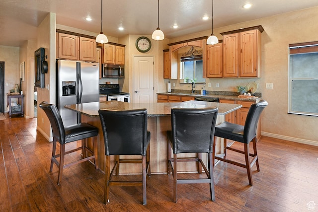 545 N 1100 E, Beaver, UT 84713 - kitchen with stainless steel appliances, dark wood-type flooring, a center island, baseboards, and a breakfast bar area