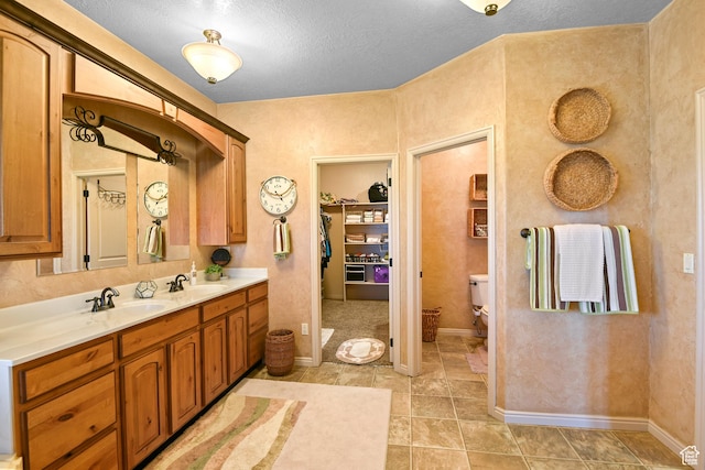 545 N 1100 E, Beaver, UT 84713 - full bath with double vanity, toilet, baseboards, a spacious closet, and tile patterned floors
