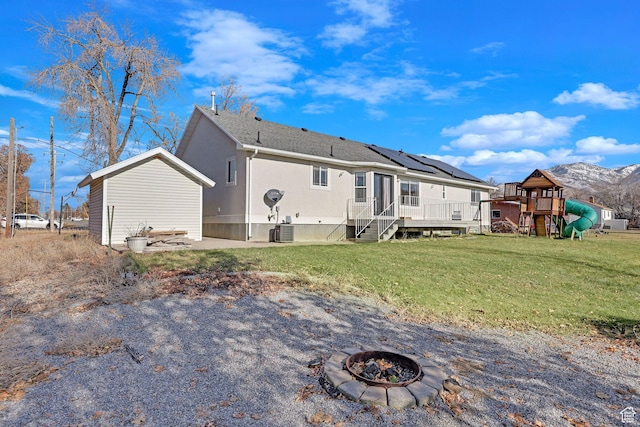 98 W 400 S, Smithfield, UT 84335 - rear view of property featuring a playground, an outdoor fire pit, a lawn, a wooden deck, and cooling unit