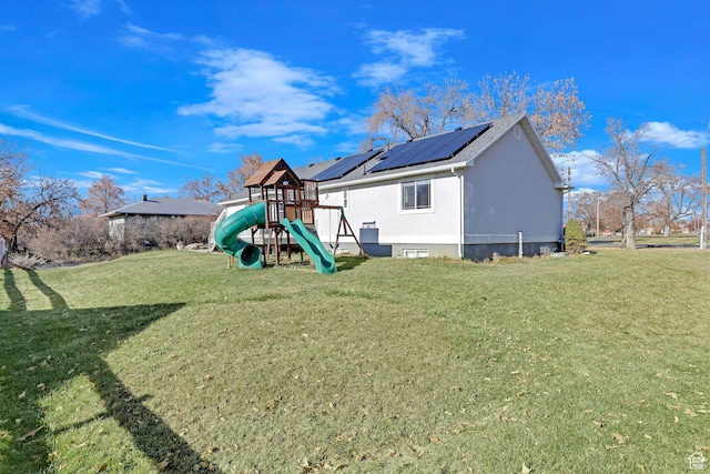98 W 400 S, Smithfield, UT 84335 - rear view of house featuring a playground, solar panels, a lawn, and stucco siding