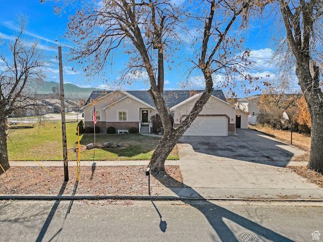 98 W 400 S, Smithfield, UT 84335 - ranch-style home with a front yard, an attached garage, concrete driveway, brick siding, and a mountain view