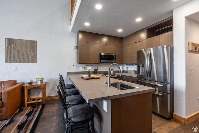 2653 W Canyons Resort Dr Unit 322, Park City, UT 84098 - kitchen with stainless steel appliances, dark wood-style flooring, a textured wall, a breakfast bar area, and open shelves
