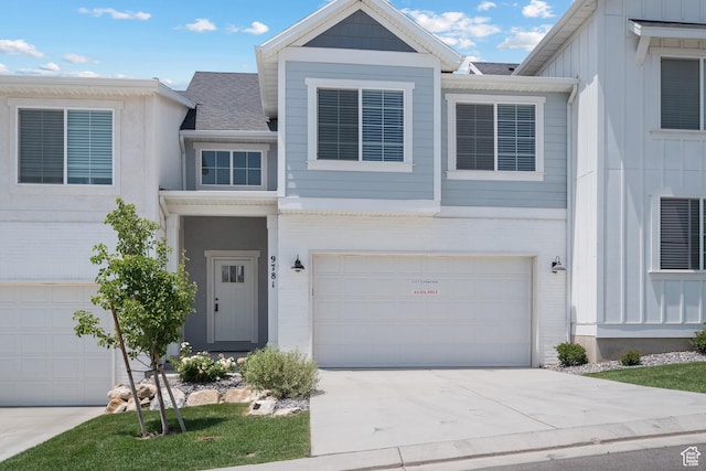9781 N Aaron Ave Unit 207, Eagle Mountain, UT 84005 - view of front of property featuring a garage, driveway, board and batten siding, and roof with shingles