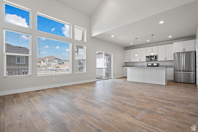 9781 N Aaron Ave Unit 207, Eagle Mountain, UT 84005 - kitchen with appliances with stainless steel finishes, open floor plan, light wood-type flooring, white cabinets, and recessed lighting
