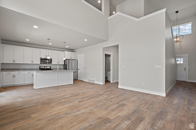 9781 N Aaron Ave Unit 207, Eagle Mountain, UT 84005 - kitchen with stainless steel appliances, white cabinetry, light wood-style floors, light stone counters, and recessed lighting