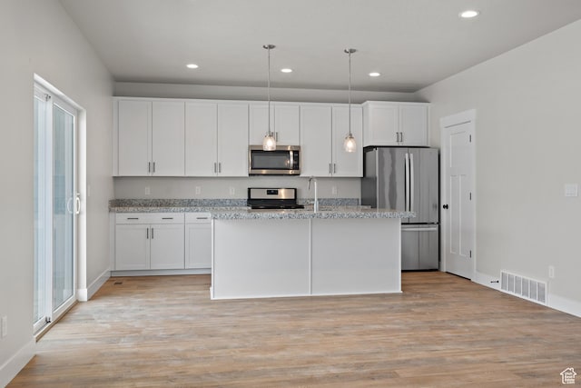 9781 N Aaron Ave Unit 207, Eagle Mountain, UT 84005 - kitchen with appliances with stainless steel finishes, recessed lighting, white cabinetry, light wood finished floors, and an island with sink