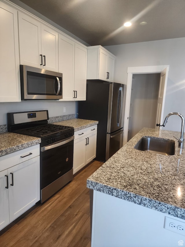 9781 N Aaron Ave Unit 207, Eagle Mountain, UT 84005 - kitchen with white cabinets, appliances with stainless steel finishes, dark hardwood / wood-style floors, and sink