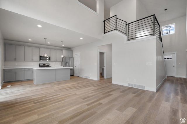 9807 N Aaron Ave Unit 210, Eagle Mountain, UT 84005 - unfurnished living room featuring a high ceiling, light wood finished floors, and recessed lighting