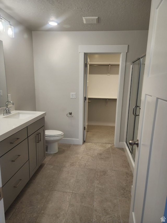 9807 N Aaron Ave Unit 210, Eagle Mountain, UT 84005 - bathroom featuring vanity, toilet, a shower with door, and a textured ceiling