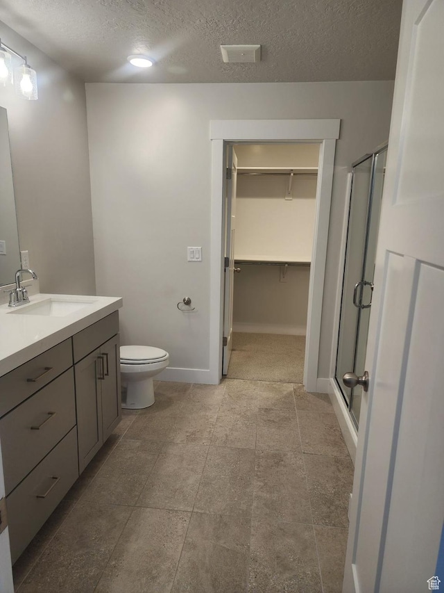 9807 N Aaron Ave Unit 210, Eagle Mountain, UT 84005 - bathroom featuring vanity, a shower stall, a textured ceiling, toilet, and a spacious closet
