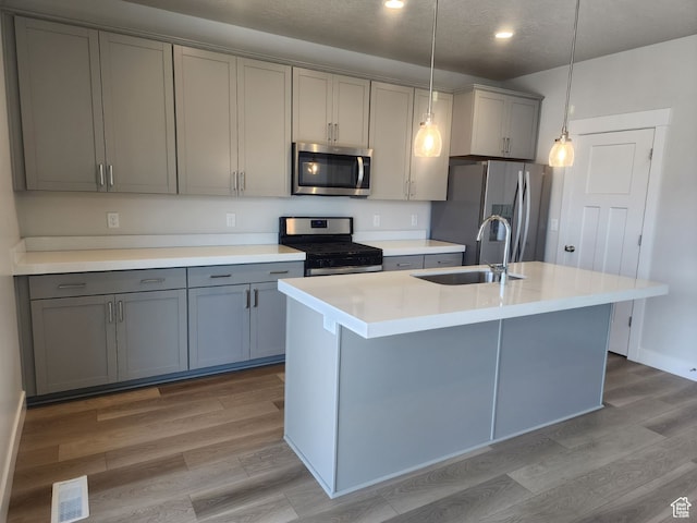 9807 N Aaron Ave Unit 210, Eagle Mountain, UT 84005 - kitchen featuring gray cabinetry, pendant lighting, sink, an island with sink, and stainless steel appliances