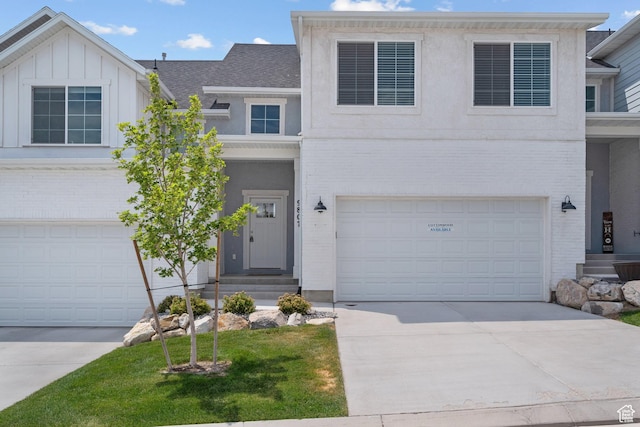 9807 N Aaron Ave Unit 210, Eagle Mountain, UT 84005 - view of front facade with brick siding, driveway, roof with shingles, and a garage