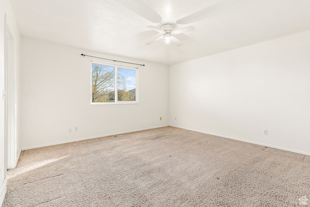 carpeted spare room featuring ceiling fan