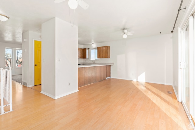 unfurnished living room with light wood-type flooring and ceiling fan