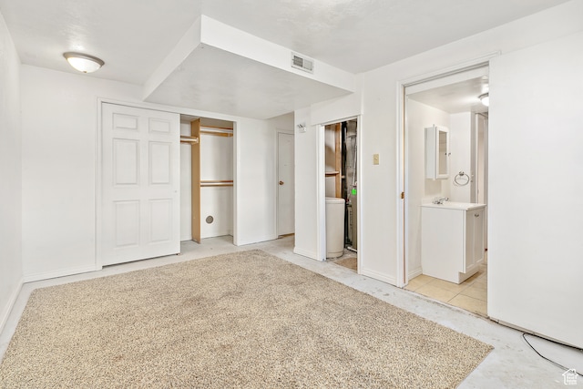 unfurnished bedroom featuring ensuite bath and sink