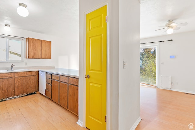 kitchen featuring dishwasher, light wood-type flooring, ceiling fan, and sink