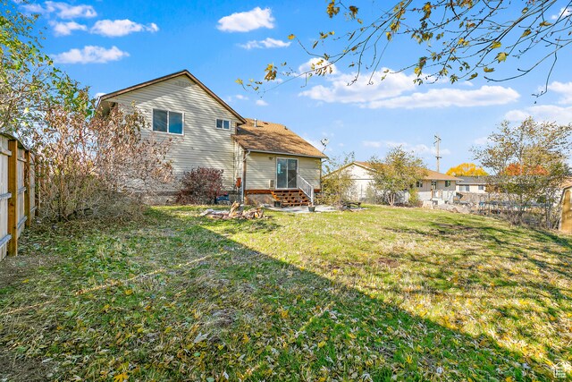 rear view of property featuring a yard