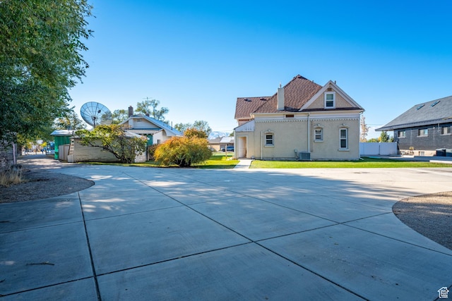rear view of property with a yard and central AC