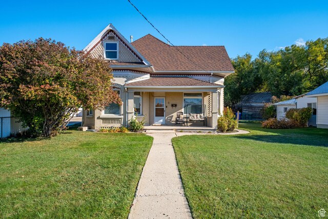 rear view of house featuring a porch and a yard