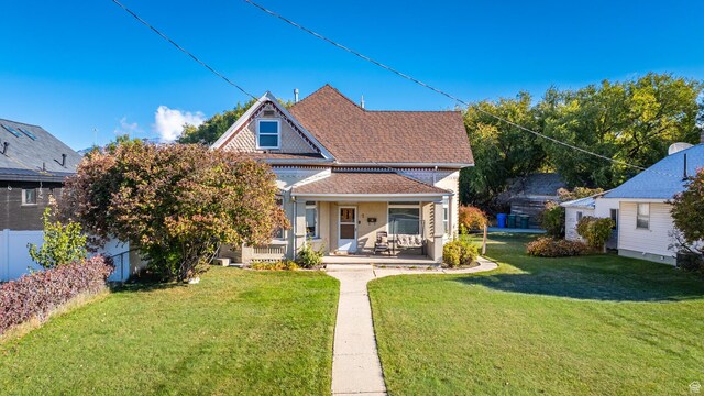 back of property featuring a porch and a yard