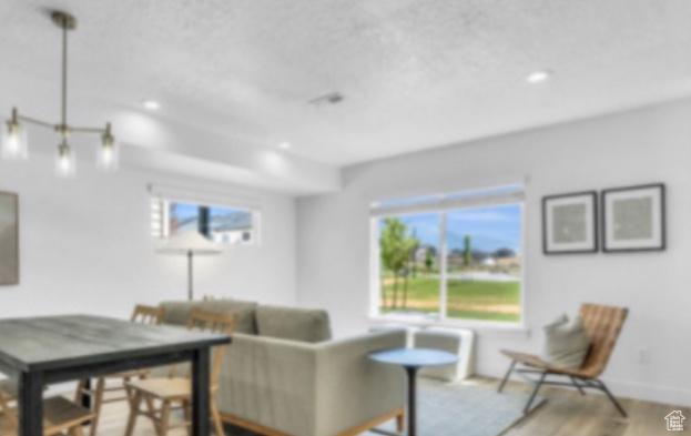 living room featuring a textured ceiling and light wood-type flooring