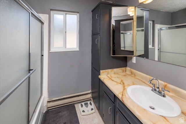281 W 600 N Unit 4, Logan, UT 84321 - bathroom with vanity, tile patterned flooring, enclosed tub / shower combo, a textured ceiling, and baseboard heating