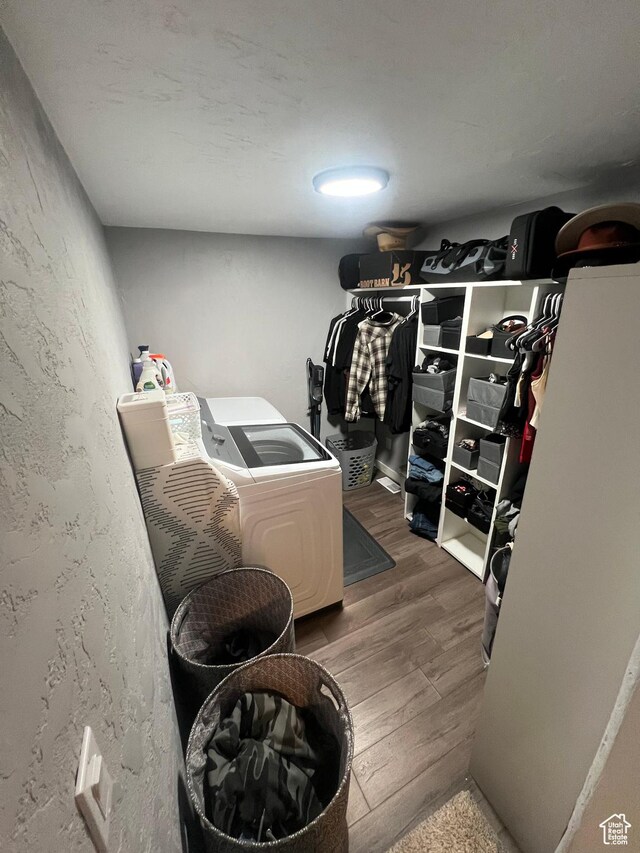 spacious closet featuring independent washer and dryer and wood finished floors