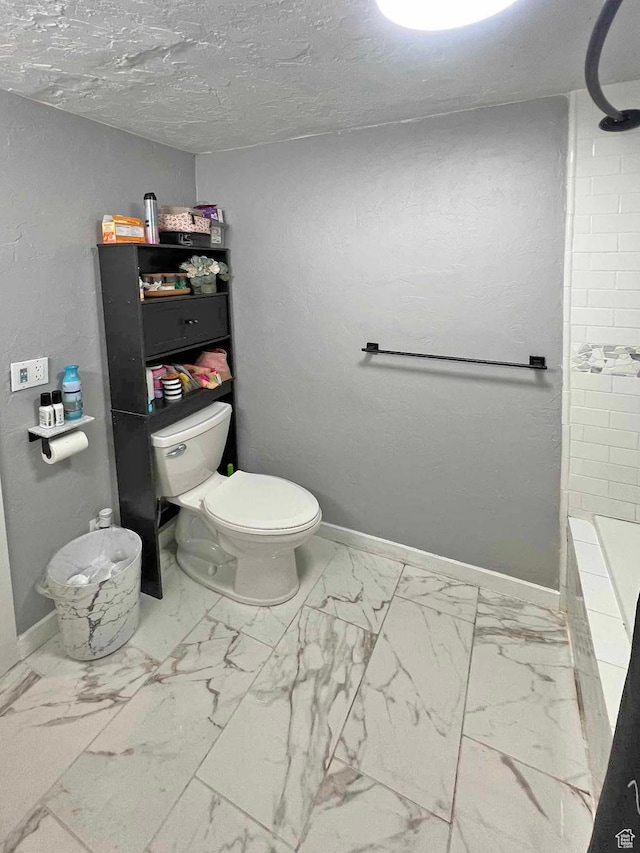 bathroom featuring tiled shower, marble finish floor, toilet, a bathtub, and baseboards