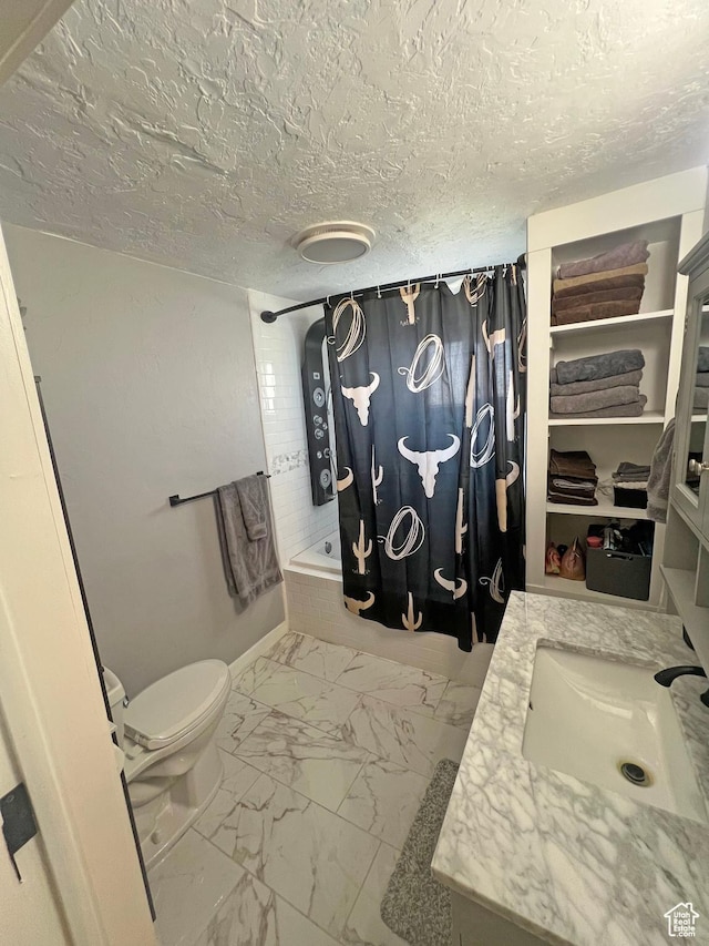 full bath with a textured ceiling, shower / tub combo, toilet, vanity, and marble finish floor