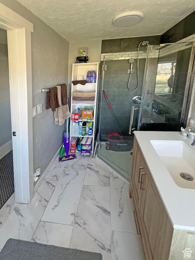 full bathroom featuring baseboards, a shower stall, marble finish floor, and vanity