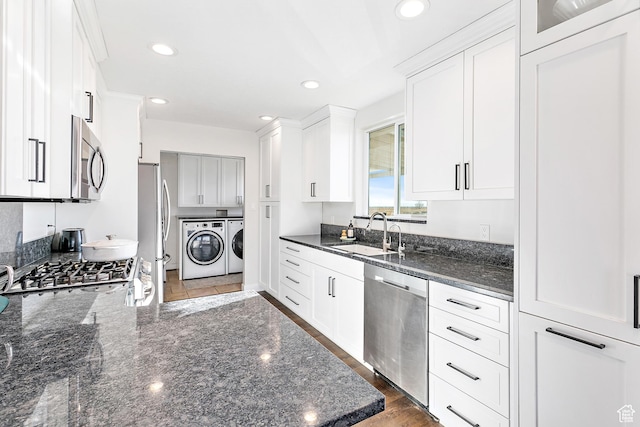 121 W Main St N, Fairfield, UT 84013 - kitchen featuring washing machine and clothes dryer, stainless steel appliances, sink, dark stone countertops, and white cabinetry