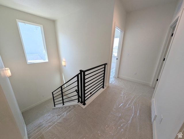 staircase with baseboards, carpet flooring, and a healthy amount of sunlight