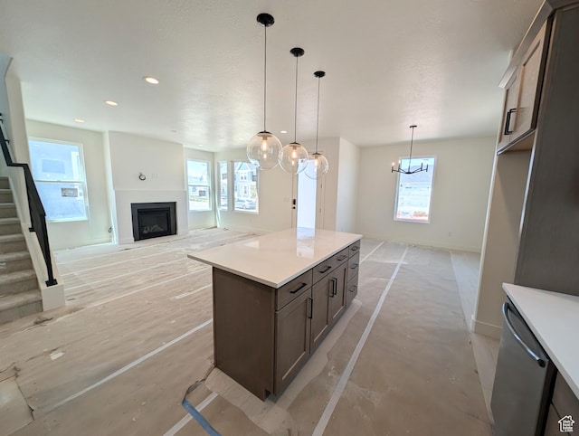 kitchen with baseboards, light countertops, a healthy amount of sunlight, and a fireplace