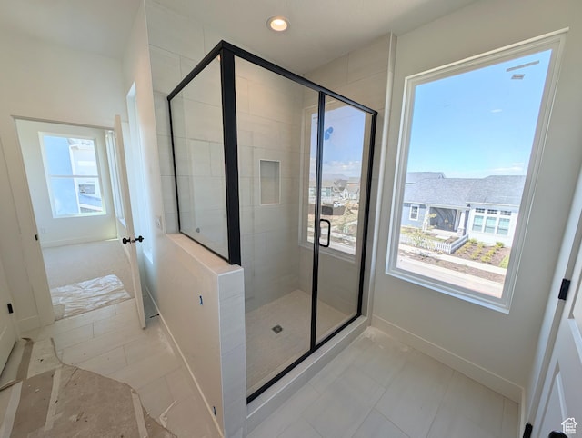 bathroom featuring baseboards and a shower stall