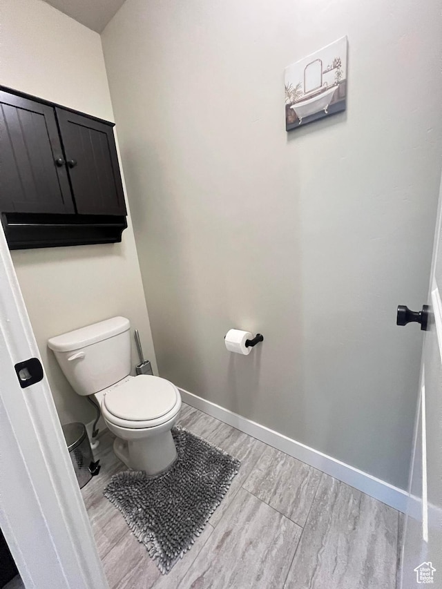 bathroom featuring wood-type flooring and toilet